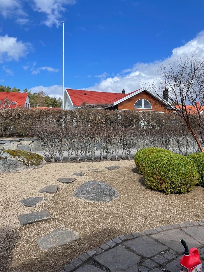 En stengång i en grusad trädgård.